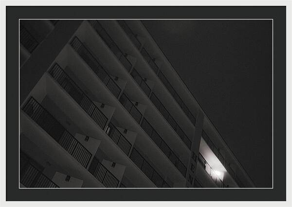 Dimly Lit Beach Hotel Building at Night - Framed Print