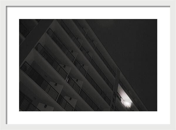 Dimly Lit Beach Hotel Building at Night - Framed Print