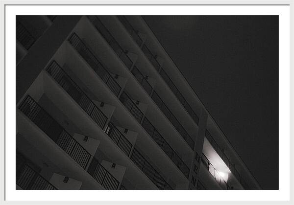 Dimly Lit Beach Hotel Building at Night - Framed Print