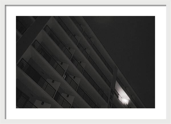Dimly Lit Beach Hotel Building at Night - Framed Print
