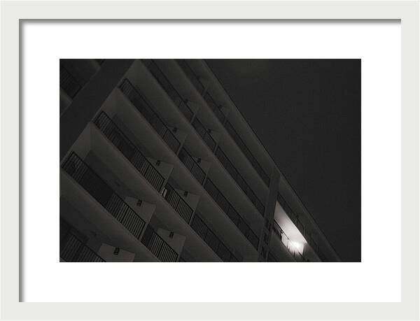 Dimly Lit Beach Hotel Building at Night - Framed Print