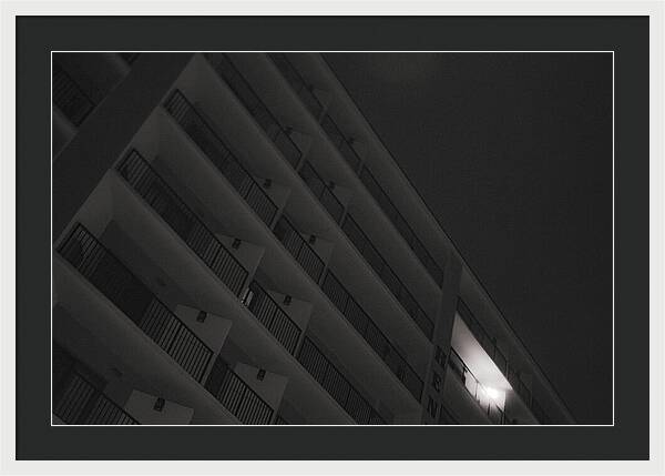 Dimly Lit Beach Hotel Building at Night - Framed Print